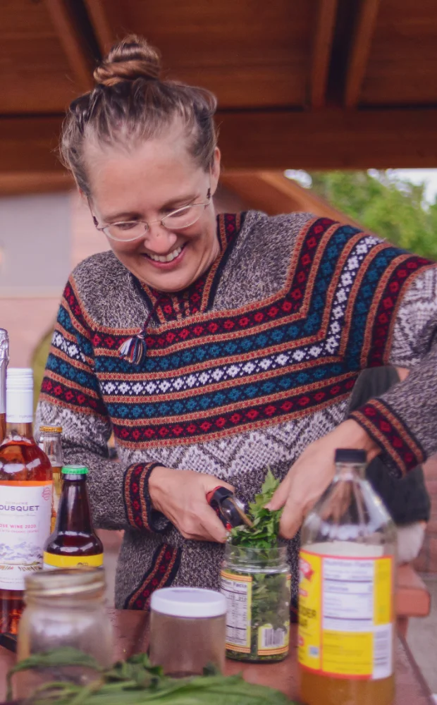 Woman preparing fresh herbs at an outdoor table